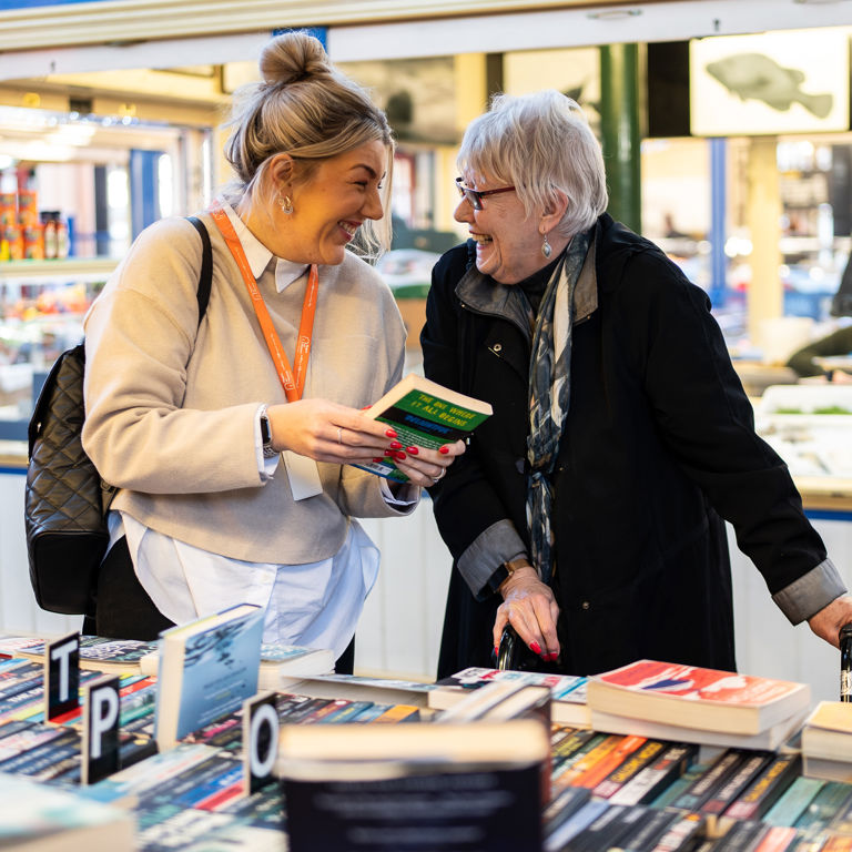 Client and Carer browsing book selection at market