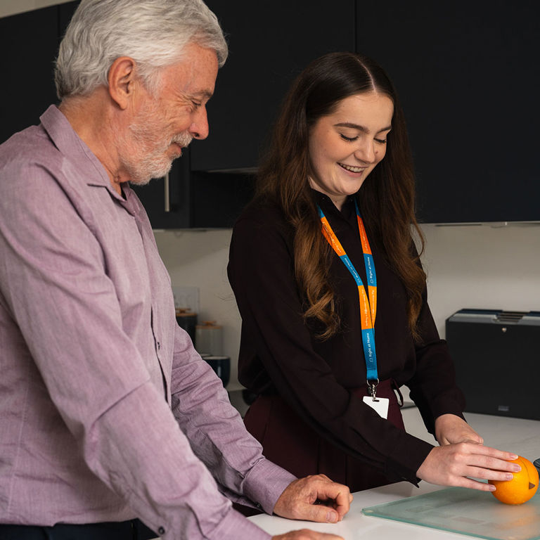 Client and Carer Cutting an orange for a healthy snack