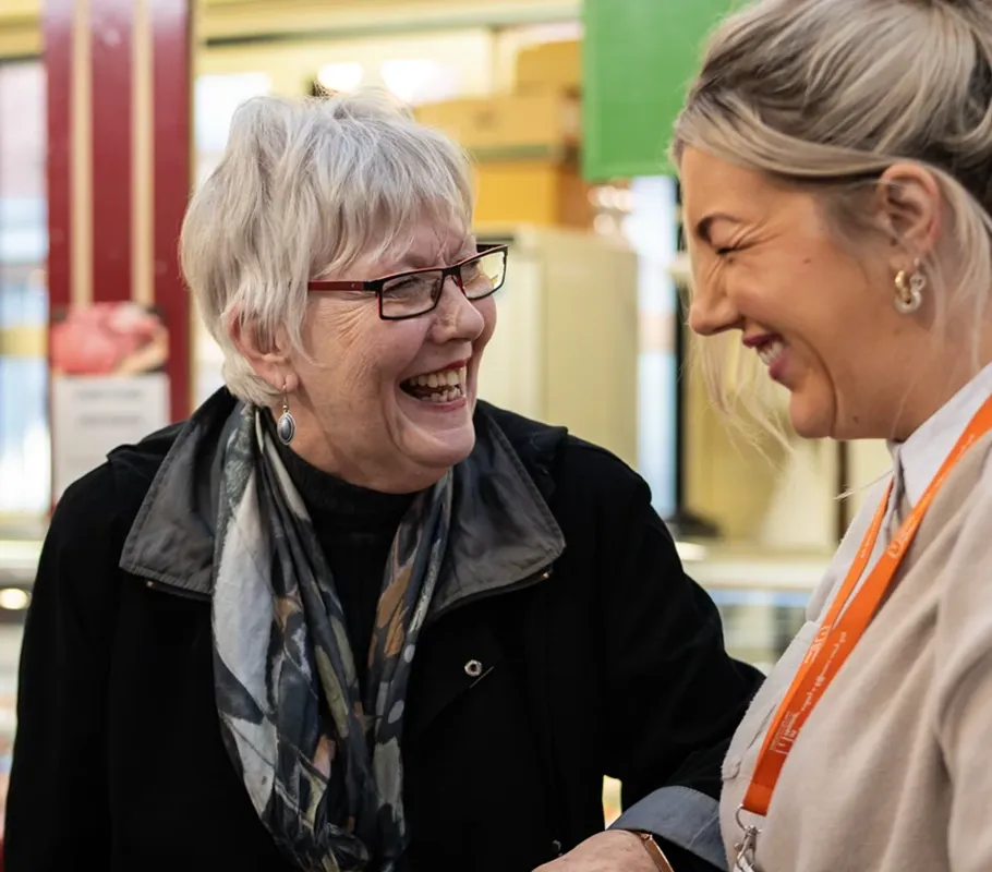 Carer accompanying an older client around a market