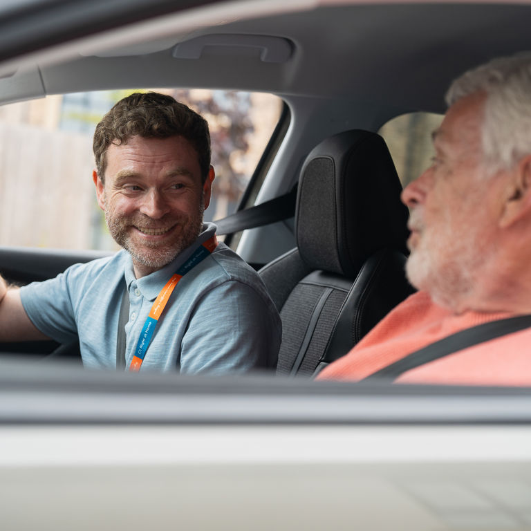 Client and Carer smiling while in car