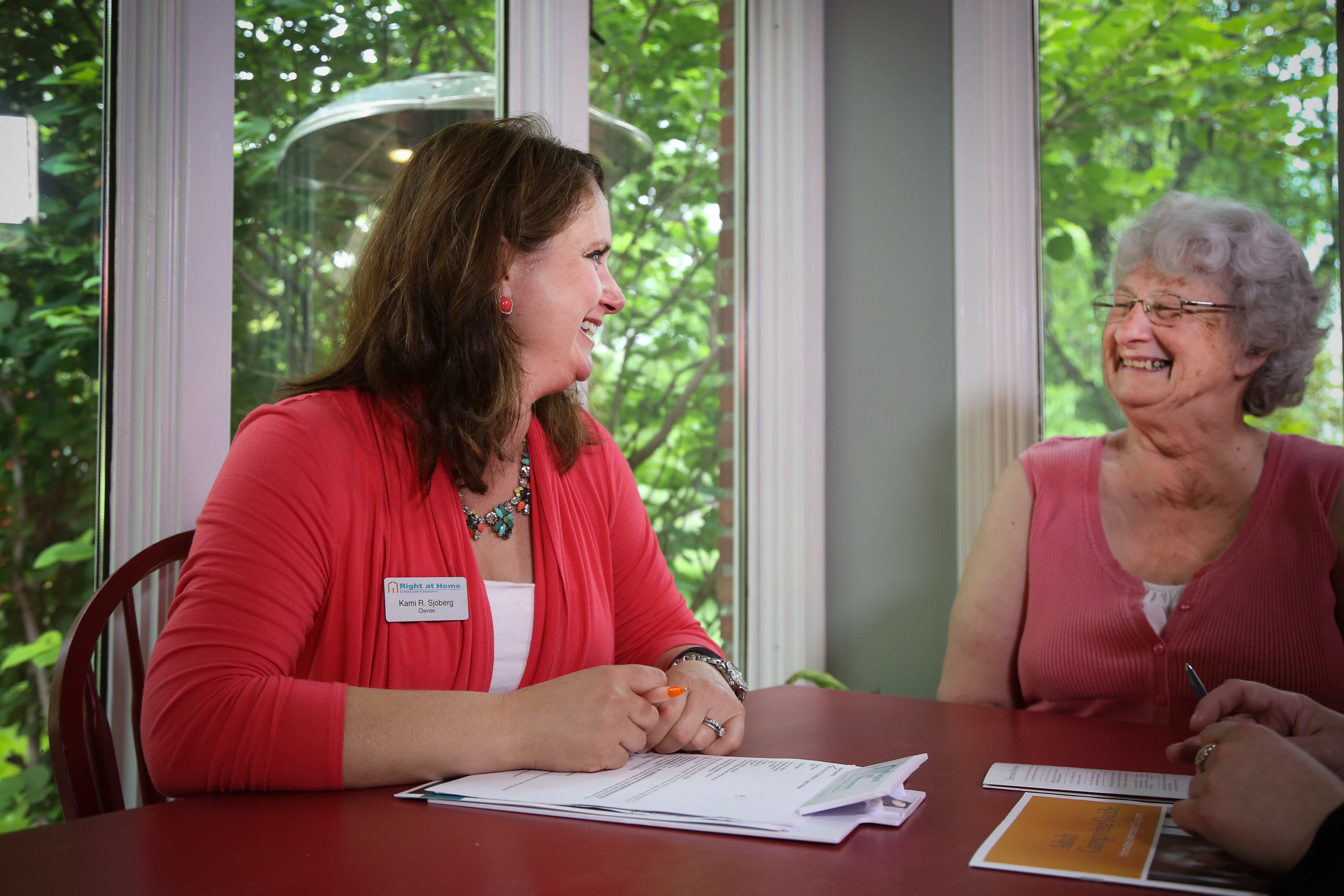 Woman helping client with homecare plans at a table