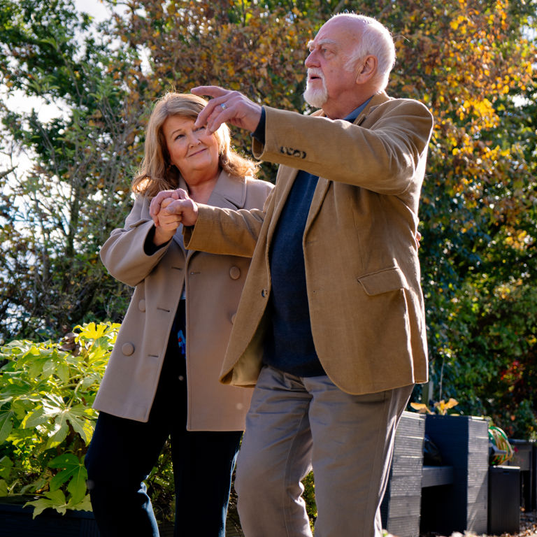Homecare Client holding hands with Carer while in garden