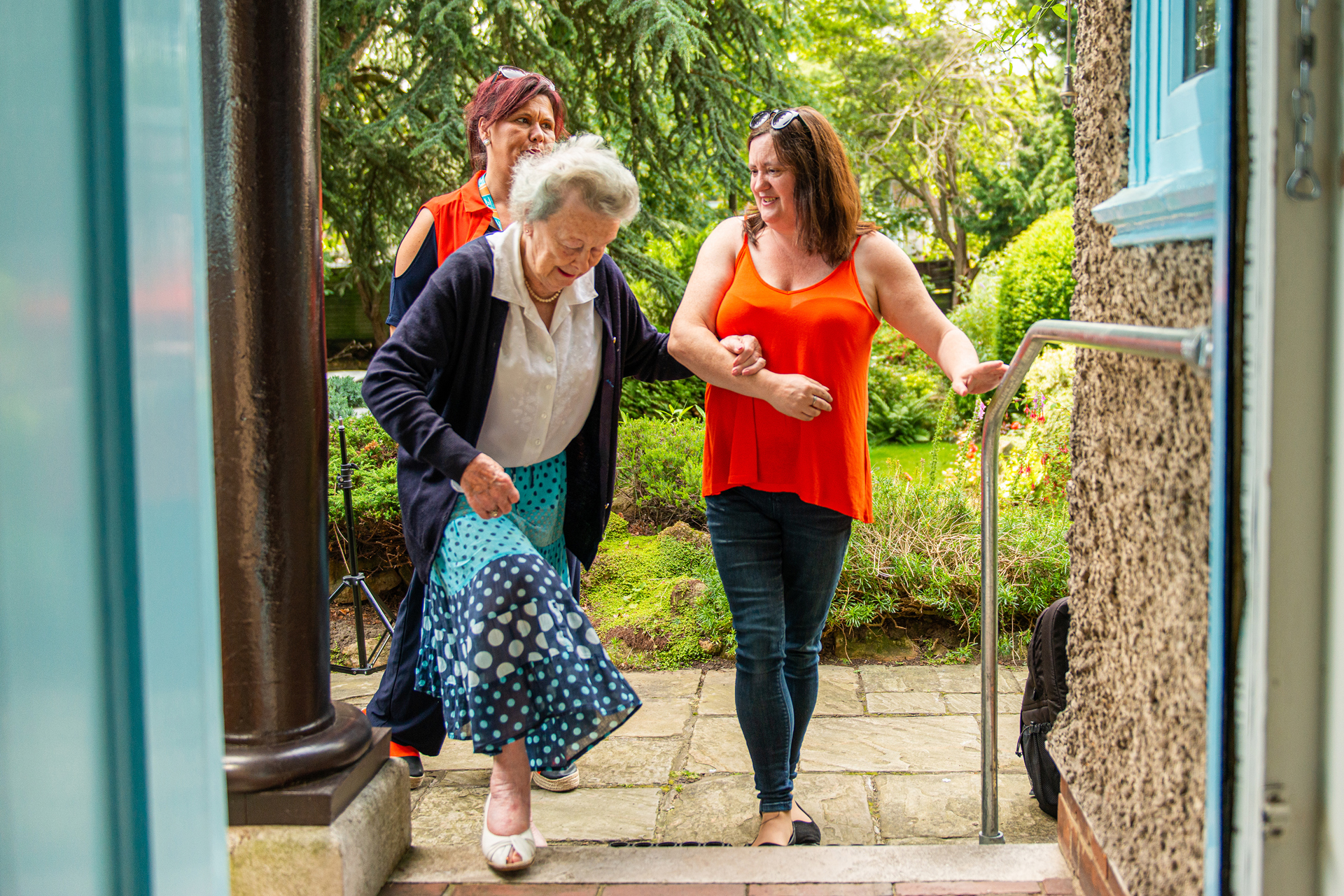 CareGivers helping client through doorway